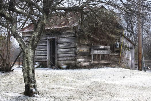Old log cabin with a dusting of snow cover.