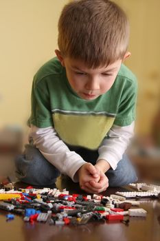 Young boy concentrating on building blocks.