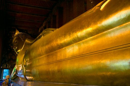 The gigantic reclining Buddha of Wat Pho in Bangkok,  within the Wat Pho (also named wat po, wat phra chetuphon or Grand Palace) in Bangkok, Thailand. 