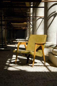 old armchair standing  among the columns