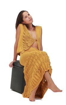 Young relaxed woman sitting on a stool,isolated against a white background.