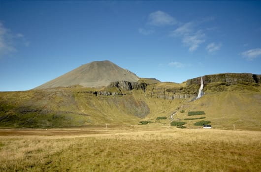 Icelandic countryside scenery with farm and waterfall