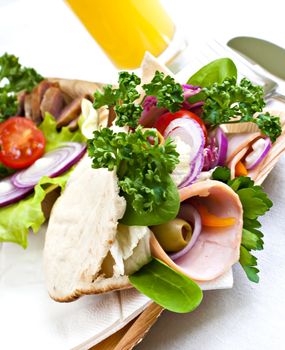 Pita bread with fresh vegetables and a glass of juice.
