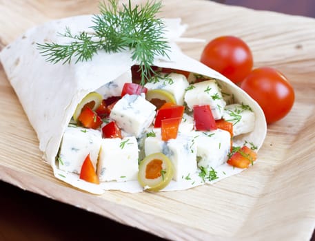 Lavash with a cheese filling, tomato, peppers, olives and fennel.