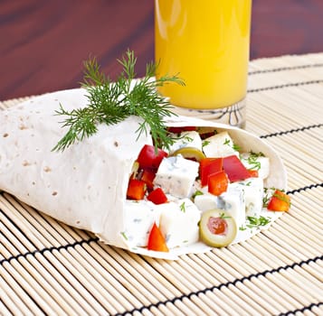 Lavash with a cheese filling and a glass of juice.