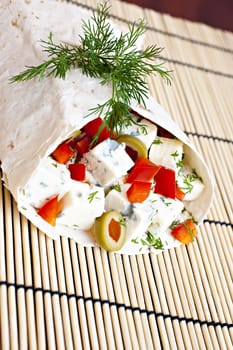 Lavash with a cheese filling, tomato, peppers, olives and fennel.