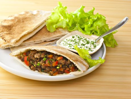 Pita bread with grilled meat and fresh salad.