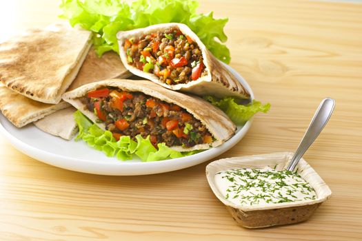 Pita bread with grilled meat and fresh salad.
