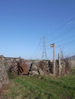 A footpath leads to a pair of gates with a sign pointing out the public access area.