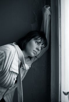 Beautiful sad brunette at a window