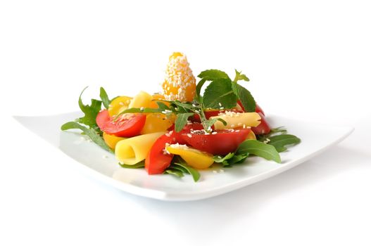 Salad of red and yellow tomato with cheese, arugula, sesame