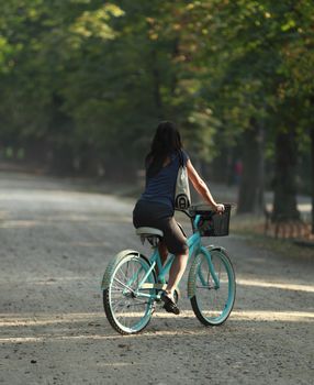 Young woman riding a bicycle in a park in the morning.