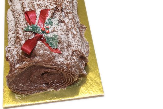 christmas chocolate yulelog with a red ribbon and holly decoration