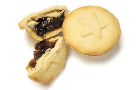 two mincepies decorated with a star design one halved ready to eat isolated over a white background