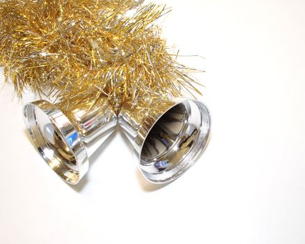 gold and silver tinsel with silver bells decorations for the christmas tree over a light background
