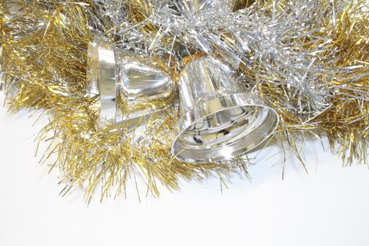 gold and silver tinsel with silver bells objects for decorating the christmas tree isolated over a white background