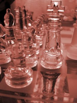 glass chess set game with a engraved glass playing board coloured red the king is the focal poin