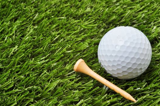 Closeup of golf ball and tee on grass with copy space.