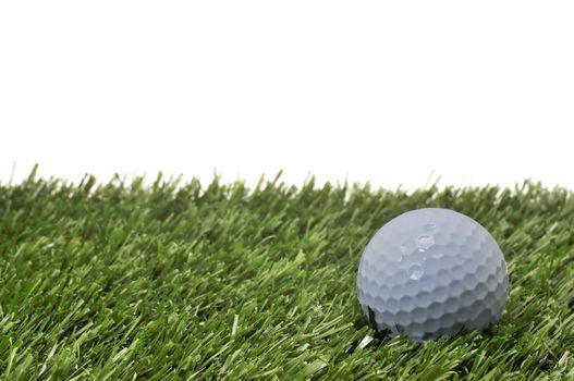 Closeup of golf ball  on grass with white background.