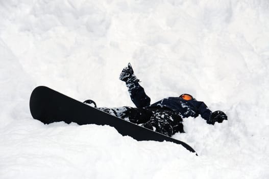 Snowboarder lying in the snow with the thumb up
