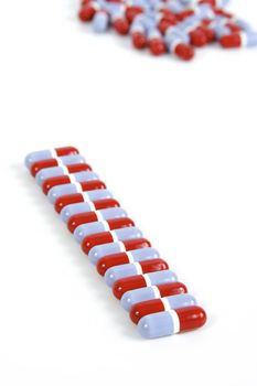 a row of blue and red pills with pills in the background on a white background.