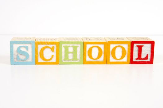 Colorful childrens blocks spell the word school.