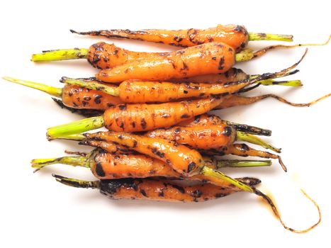 close up of caramelized baby carrots isolated on white