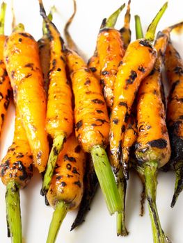 close up of caramelized baby carrots isolated on white