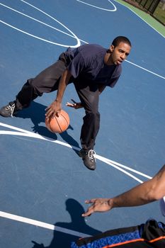 A young basketball player posts up against his opponent during a one on one basketball game.