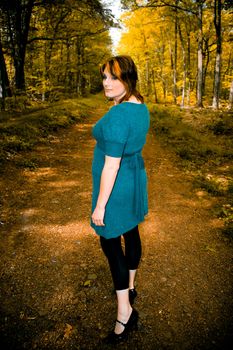 A young woman posing on a wooded path.