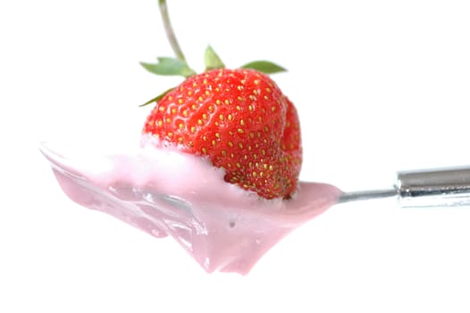 Strawberry in the spoon full of Yoghurt