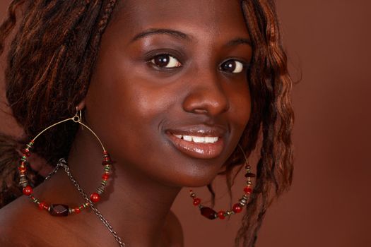 closeup portrait of a beautiful african girl, brown background