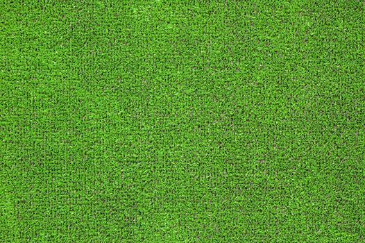 A green artificial grass for sports fields, covering, gardens. Plastic or grass background texture