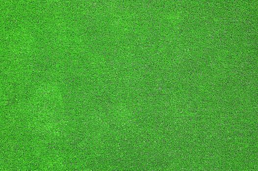 A green artificial grass for sports fields, covering, gardens. Plastic or grass background texture