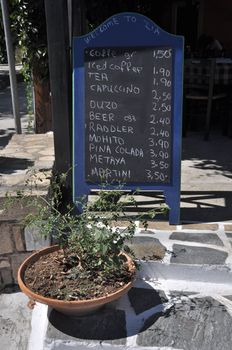 classic taverna ad with a chalkboard menu and stone painted in Zia (Kos island), Greece