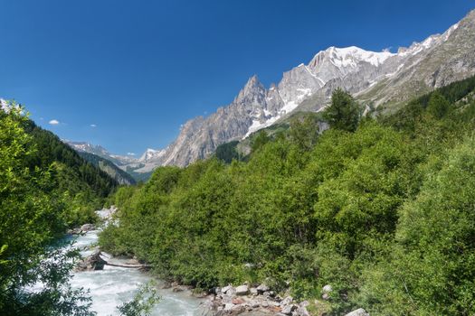 small stream in Ferret valley on summer with Mont Blanc on background