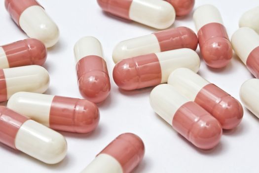 Pink capsules isolated on white background 
