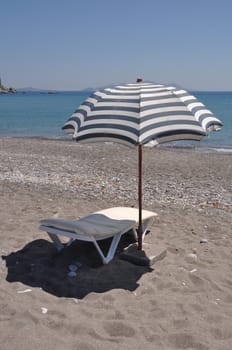 gorgeous beach scene with greek umbrella and chair at Kefalos beach (Kos), Greece