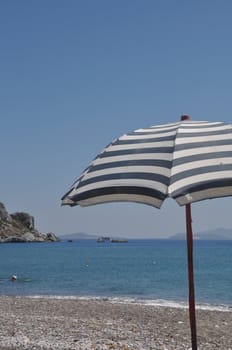 gorgeous beach scene with greek umbrella at Kefalos beach (Kos), Greece