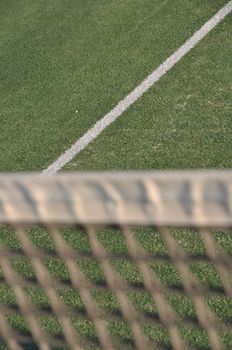 white line on an outdoor tennis court (defocused net)