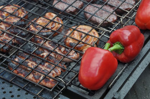 grilling fresh meat and pepers on a outdoor barbecue