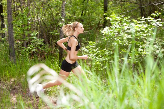 Young woman running in the forest on trail