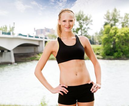 Young woman standing near bridge and posing