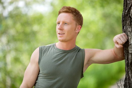 Close-up of a man smiling, looking away against blur background