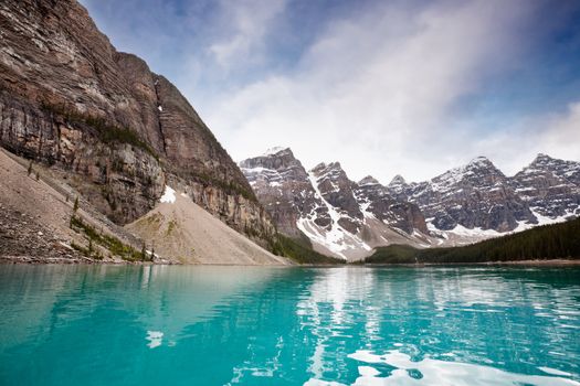 Scenic shot of calm blue water and mountain range against sky