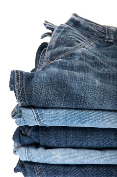 stack of blue jeans isolated on white background