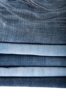 stack of blue jeans isolated on white background