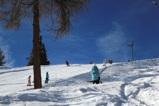 People skiing by beautiful weather in Alps mountain, Switzerland