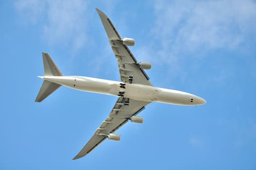 Large airplane flying in the blue sky.