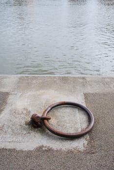 old and rusty mooring ring for ships on dock